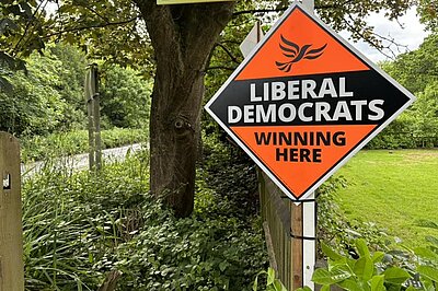 A Liberal Democrat Stakeboard by a peaceful green lane